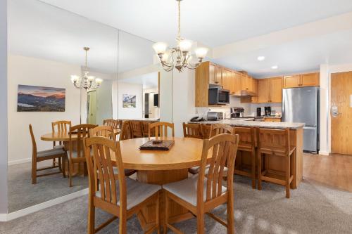 a kitchen and dining room with a wooden table and chairs at The Woodrun Lodge by Whiski Jack in Whistler