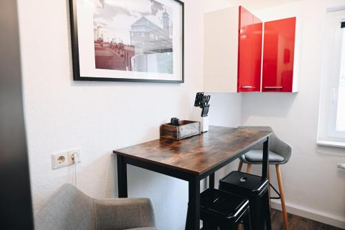 a desk in a room with a chair and a picture at Oberwiesenthal Apartments in Kurort Oberwiesenthal