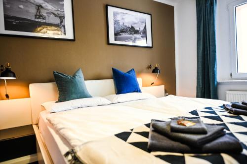 a bedroom with two beds with blue and white pillows at Oberwiesenthal Apartments in Kurort Oberwiesenthal