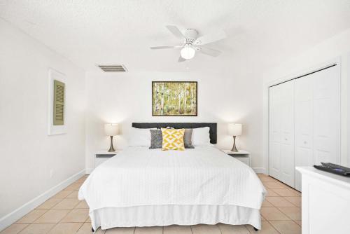 a white bedroom with a bed and a ceiling fan at Dog Friendly Cottage Just North of Historic St Aug in Saint Augustine