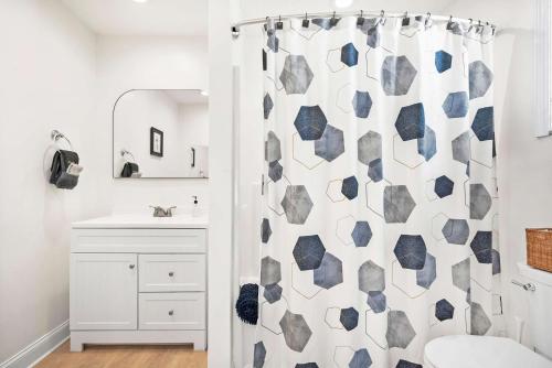 a bathroom with a shower curtain and a sink at Dog Friendly Cottage Just North of Historic St Aug in Saint Augustine