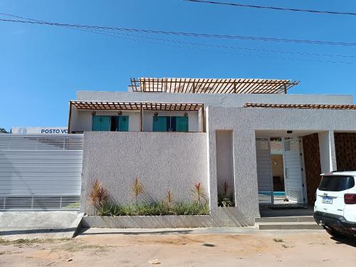 a white car parked in front of a house at Flats Marina Maragogi in Maragogi
