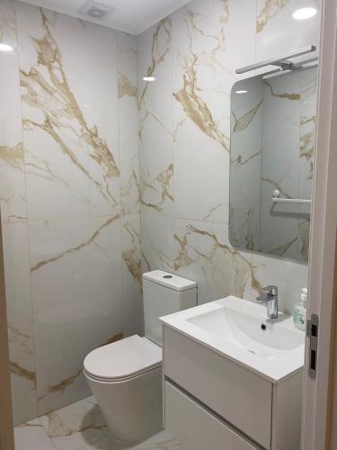 a white bathroom with a toilet and a sink at Leiras da Cachada - Gerês in Valdosende