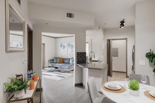 a kitchen and a living room with a table and chairs at Beautiful 2 BR 2 BA, NRG, Medical Center, Downtown, Free WiFi, Pool in Houston
