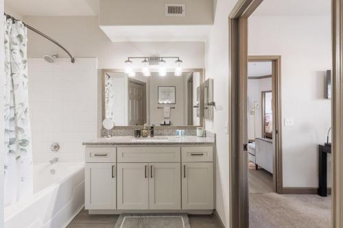 a bathroom with a sink and a tub and a mirror at Beautiful 2 BR 2 BA, NRG, Medical Center, Downtown, Free WiFi, Pool in Houston