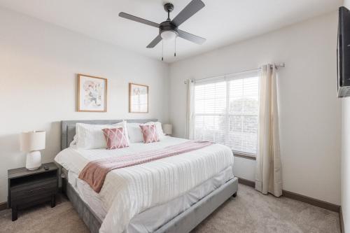 a white bedroom with a bed and a ceiling fan at Beautiful 2 BR 2 BA, NRG, Medical Center, Downtown, Free WiFi, Pool in Houston