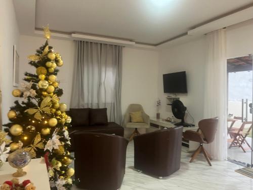 a christmas tree in a living room with a couch at Lar do Mar in Salinópolis