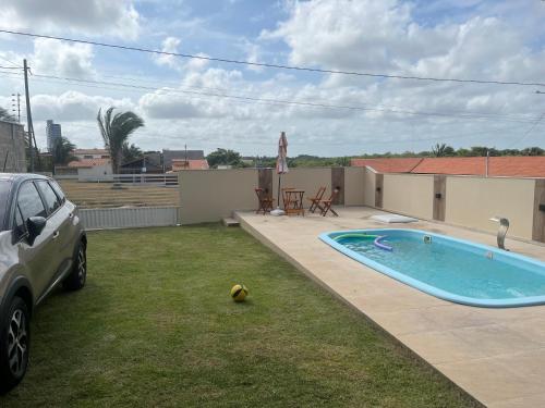 a car parked in a yard with a swimming pool at Lar do Mar in Salinópolis