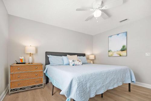 a bedroom with a bed and a ceiling fan at Secret Cottage 10 min to DT Dogs OK BBQ Parking in Saint Augustine
