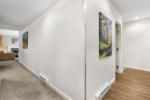 an empty hallway with two paintings on the wall at The Woodrun Lodge by Whiski Jack in Whistler
