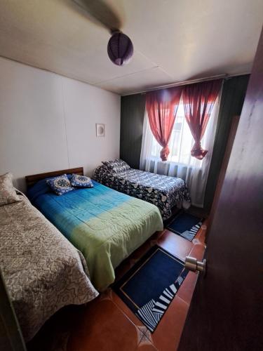 a bedroom with two beds and a window at Cabaña puerto varas in Puerto Varas