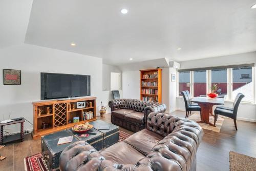 a living room with couches and a table and a television at Nirvana Farm, Clevedon in Clevedon