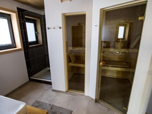 a bathroom with two sinks and a glass door at "NisseHus" Comfortable holiday residence in Felle
