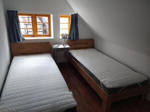 Dos camas en una habitación pequeña con ventana. en De Böhn Comfortable holiday residence, en Travemünde