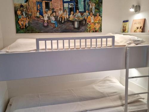 a bedroom with two bunk beds with a painting on the wall at The Blue House Modern retreat in Wangerooge