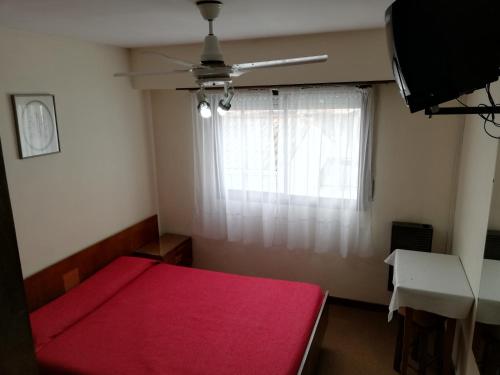 ネコチェアにあるNecochea Real Hotelのベッドルーム1室(赤いベッド1台、窓付)