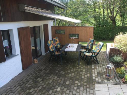 a patio with a table and chairs on a patio at Holiday home chalet on the castle hill in Brotterode-Trusetal