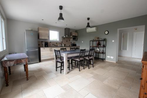 une cuisine et une salle à manger avec une table et des chaises dans l'établissement Mas des Cyprès, clim - jardin en Camargue, à Arles