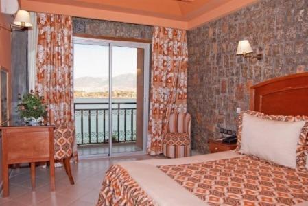 a bedroom with a bed and a window with a balcony at Chems Du Lac Bin El Ouidane in Bine el Ouidane