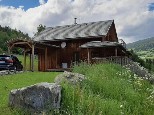 a wooden house with a car parked in front of it at Alpenglöckchen Comfortable holiday residence in Stadl an der Mur