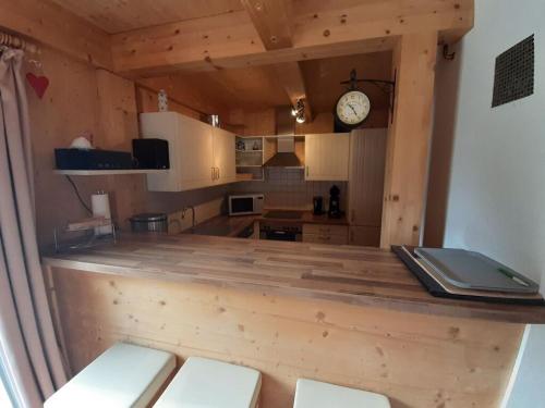a kitchen with a wooden counter with a clock on the wall at Alpenglöckchen Comfortable holiday residence in Stadl an der Mur