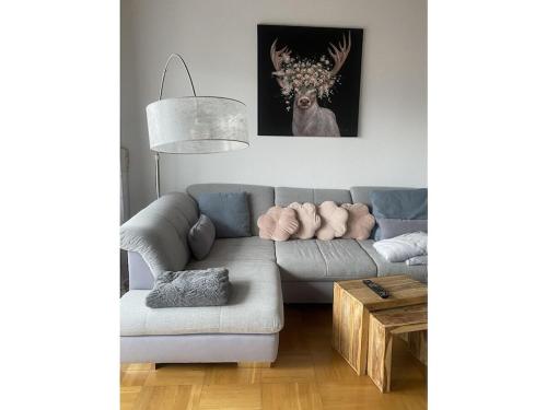 a living room with a couch and a deer painting at Villa Alpenblick Comfortable holiday residence in Füssen