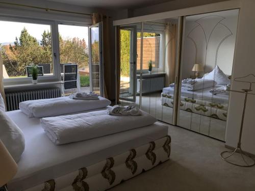 a bedroom with two beds and a large window at Villa Alpenblick Comfortable holiday residence in Füssen
