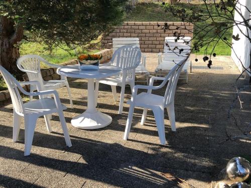 four white chairs and a table and a table and chairs at Villa Alpenblick Comfortable holiday residence in Füssen