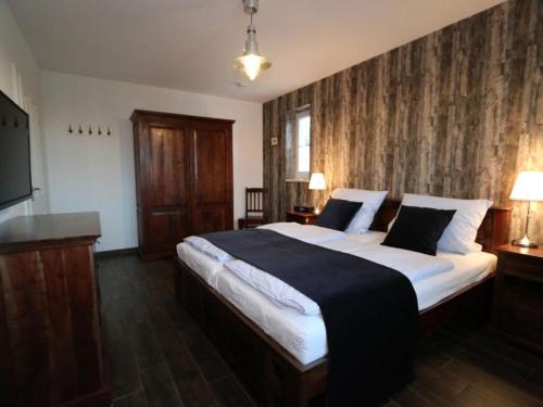 a bedroom with a large bed and a television at To"n Lüchtfüer Comfortable holiday residence in Dwarsdorf