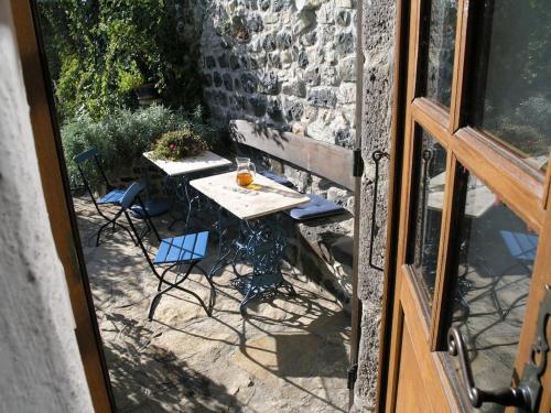 - une table et des chaises sur une terrasse à l'extérieur d'une fenêtre dans l'établissement Holiday home Mirabel Sous les roches, à Mirabel