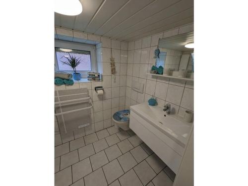 a bathroom with a tub and a sink and a toilet at Huus Meta Modern retreat in Krummhörn