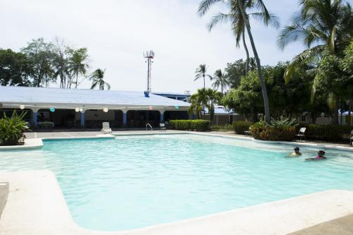 two people swimming in a large swimming pool at Puerto Azul Hotel in Puntarenas