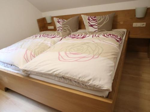 a bed with red and white blankets and pillows at Holiday home chalet on the castle hill in Brotterode-Trusetal