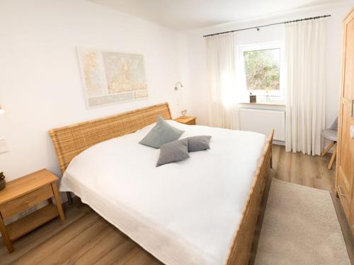 a bedroom with a white bed with two pillows on it at The Waldhaus Modern retreat in Neerdar