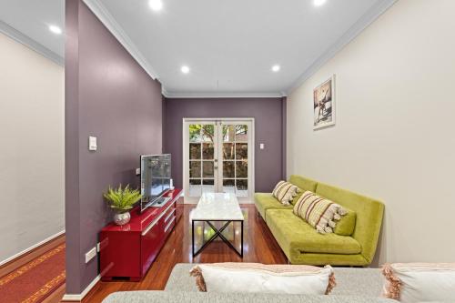 a living room with a couch and a tv at Comforting 2BR House & FishMarket & Casino-3 mins walk in Sydney