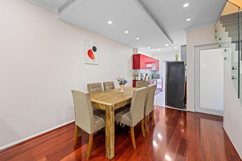 a kitchen and dining room with a wooden table and chairs at Comforting 2BR House & FishMarket & Casino-3 mins walk in Sydney