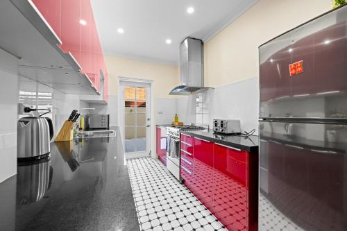 a kitchen with red cabinets and a red and white tile floor at Comforting 2BR House & FishMarket & Casino-3 mins walk in Sydney