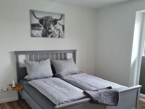 a bed in a bedroom with a picture of a bull at Holiday home Stieglund in Jörl