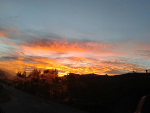 a sunset with the sun setting in the sky at Apartment Steger in Mittersill