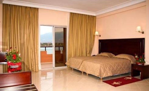 a bedroom with a bed and a balcony at Chems Du Lac Bin El Ouidane in Bine el Ouidane