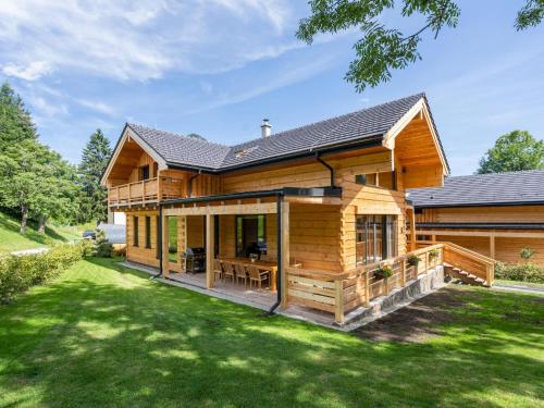 a log home with a porch and a lawn at Holzchalet Tauplitz in Tauplitz
