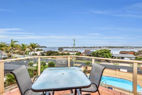 a patio with a table and chairs on a balcony at Baywatch 5 in Merimbula