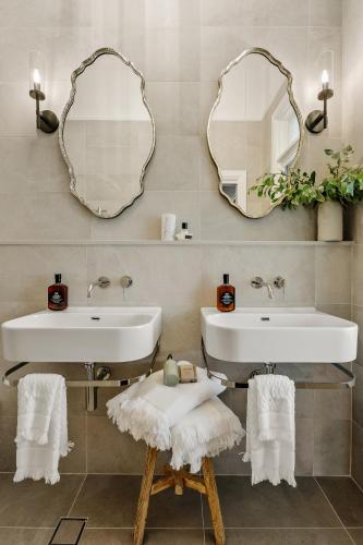a bathroom with two sinks and mirrors on the wall at Narraweema Guesthouse - Historic Luxury BnB Retreat in Gloucester