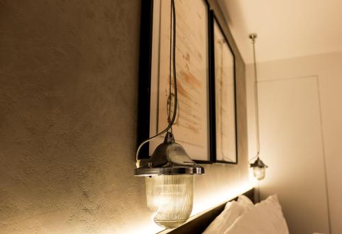 a lamp hanging on a wall with a picture at Hotel Indigo London - 1 Leicester Square by IHG in London