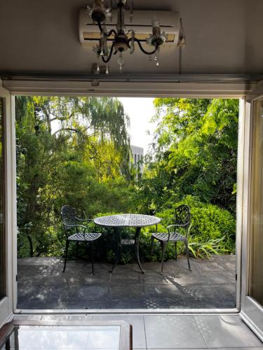 a patio with a table and chairs in front of a window at Casa Balcón del Golf in Sierra de los Padres