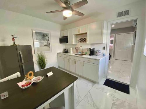 a kitchen with white cabinets and a black counter top at Little Paradise In Palm Beach in West Palm Beach