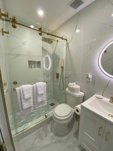 a bathroom with a shower and a toilet and a sink at Little Paradise In Palm Beach in West Palm Beach