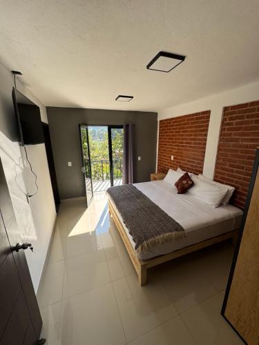 a bedroom with a bed and a brick wall at Casas Victoria in San Cristóbal de Las Casas