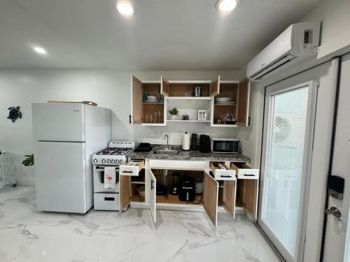 a kitchen with a white refrigerator and a sink at Palm Beach Paradise in West Palm Beach