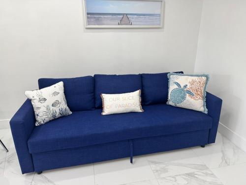 a blue couch in a room with pillows on it at Palm Beach Paradise in West Palm Beach